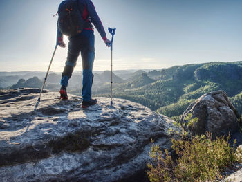 Hurt strong man stand with crutches on mountain.  elderly man walking with help of forearm crutchesg