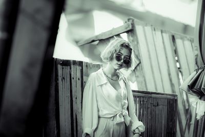 Portrait of young woman wearing sunglasses standing outdoors