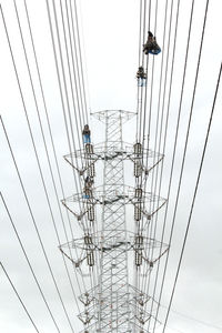 Low angle view of electricity pylon against clear sky