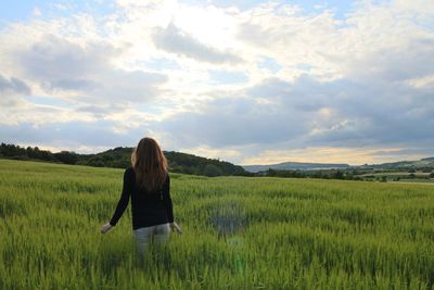 Scenic view of grassy field against cloudy sky