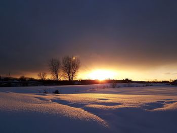 Scenic view of snow field against sky during sunset