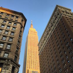 Low angle view of empire state building against sky in city
