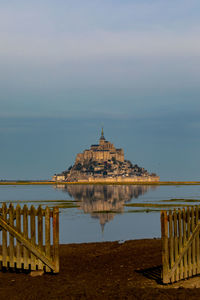 Built structure on sea against cloudy sky