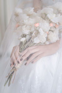 Woman holding bouquet of white flower