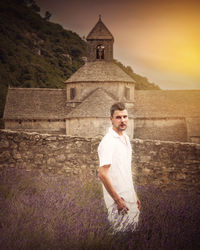 Portrait of man standing amidst lavender against abbaye de senanque