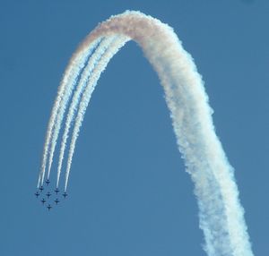 Low angle view of fighter planes performing airshow on clear sky
