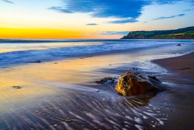 Scenic view of beach against sky during sunset