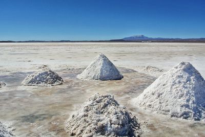 Scenic view of desert against clear blue sky