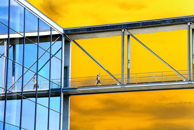 Metallic structure on bridge against sky during sunset