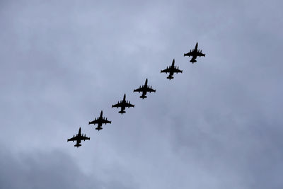 Black silhouettes of six russian military tactical frontline bombers su-25 flying in gloomy sky