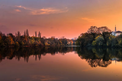 Reflection of trees in lake against sky during sunset