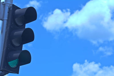 Low angle view of road signal against blue sky