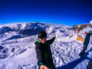 Full length of people on snowcapped mountain against sky