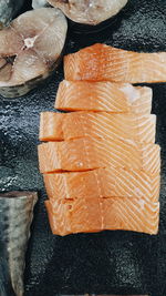 Directly above shot of sliced salmon fish on black marble