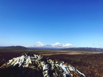 Scenic view of snowcapped mountains against clear blue sky