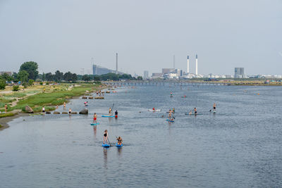 People at beach against clear sky