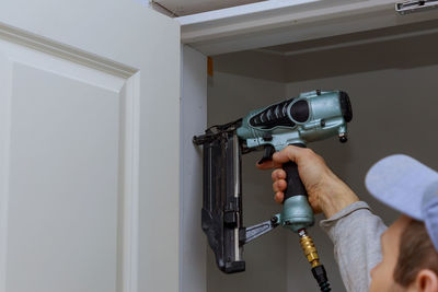 Carpenter using drill at door