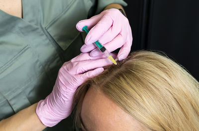 Close-up of woman applying nail