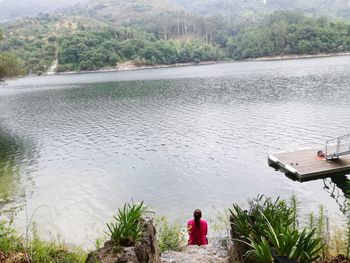 Rear view of man and woman looking at lake