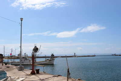 Boats moored at harbor against sky