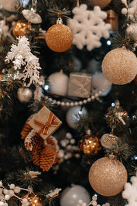 Festive christmas tree decorated with golden gifts, snowflakes and glitter christmas balls