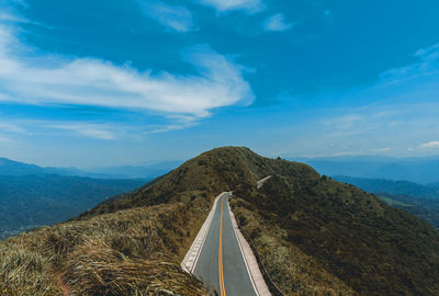 Panoramic view of road leading towards mountains against sky