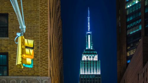 Low angle view of illuminated empire state building against sky