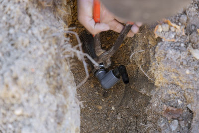 High angle view of person hand on rock