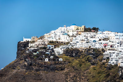 Buildings in town against clear blue sky