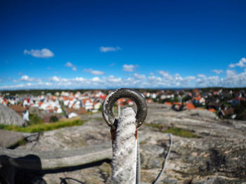 Close-up of rope passing through loop with city in background