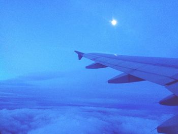 Cropped image of airplane flying over cloudscape