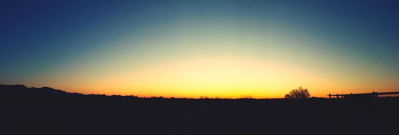 Silhouette landscape against clear sky during sunset