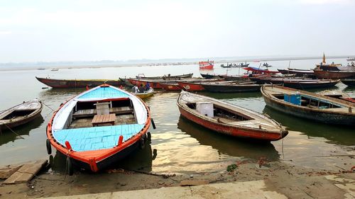 Boats moored on beach against clear sky