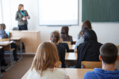 Rear view of students sitting in classroom