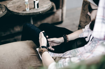 High angle view of man using phone while sitting on couch