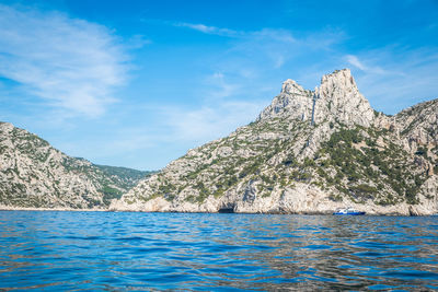 Scenic view of sea and rocks against blue sky