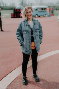 Portrait of smiling young woman standing on road