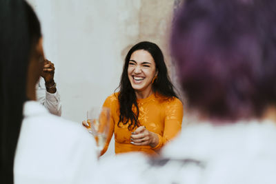 Cheerful businesswoman laughing during interacting with colleagues during event at convention center