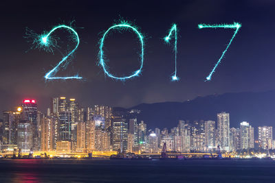 Illuminated modern buildings against sky at night