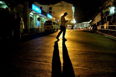 Man standing in illuminated city at night