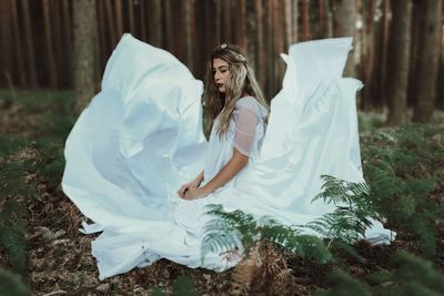 Young woman against tree