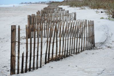 Wooden fence on beach during winter