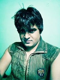 Portrait of young man standing against wall