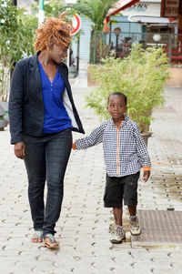 This young woman walks with her little boy by talking to different places visited.