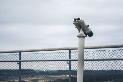 Coin-operated binoculars against sky
