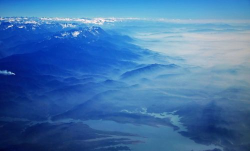 Aerial view of mountains against blue sky