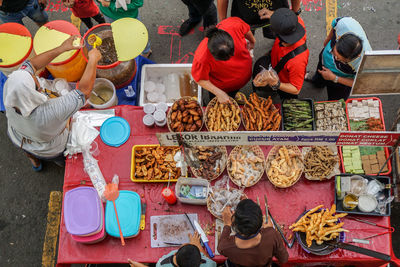 High angle view of people for sale at market stall