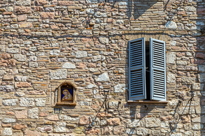 Low angle view of window on wall of old building