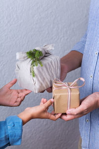 Midsection of couple holding plant in box