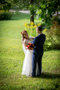 Young couple kissing flower on field